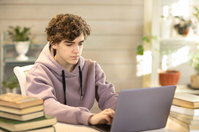 High school student using his laptop.