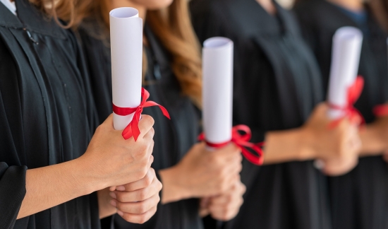 Photo of college graduates holding diplomas