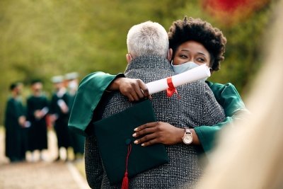 Photo of black college graduate hugging at her graduation