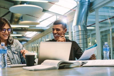 Photo of two college students smiling while studying together