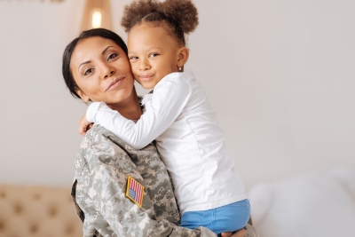 Military mom and daughter hugging